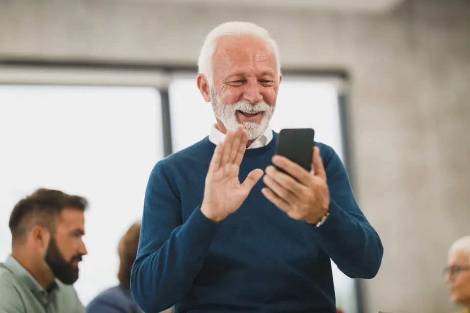 Smiling older man on a video call on a smartphone